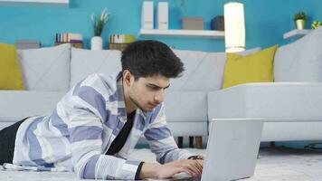 jovem homem usando computador portátil pensa e encontra ideia. video