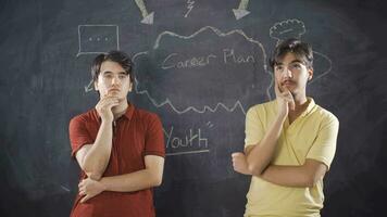 Young man writing Career Plan on blackboard. video