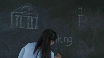 de vrouw wie schrijft bank Aan de schoolbord looks omhoog met een verdrietig uitdrukking. video