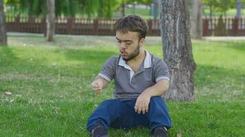 Self-motivated dwarf young man in the park. Upload motivation. video