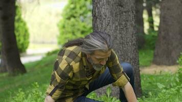 hombre con pérdida de equilibrar es sentado en el parque. video