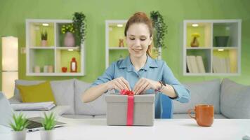 le Jeune femme qui reçoit une cadeau sur une spécial journée devient heureux. video