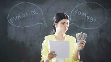 Woman writing Property Damage on blackboard looks at camera angrily and angrily. video