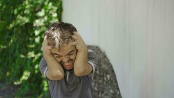 Dwarf young man having a nervous breakdown outside. video