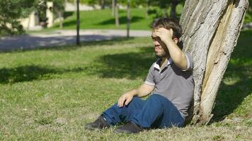 Depressed and thoughtful dwarf young man sits on the floor. video