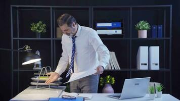 Angry businessman messing up standing desk in office. video