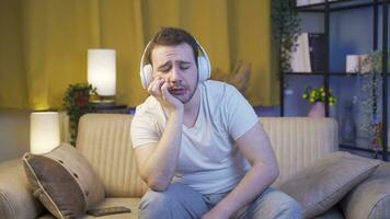Deprimido hombre escuchando a música a hogar a noche. video