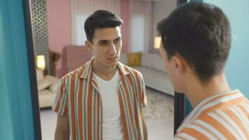 The man looks at himself in the mirror and gets sad and thinks ugly. video