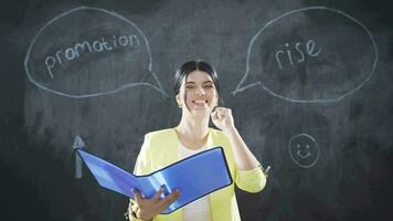 Woman writing Promotion on blackboard looks at camera cheerful and joyful. video