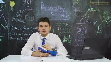 Businessman writes Personality Analysis on the blackboard and takes notes. video
