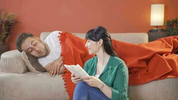 A woman reading a book to her husband. Happy couple. video