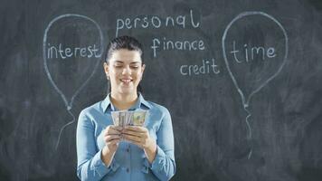 The woman who writes Consumer Loans on the blackboard looks with a happy expression. video