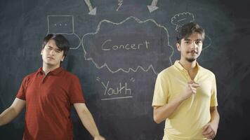 Young man writing Concert on the blackboard. video