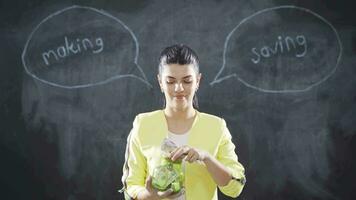 The woman who writes Savings on the board looks cheerfully at the camera. video