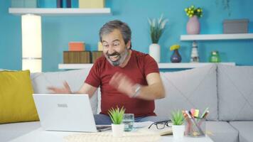 The man who is happy with what he sees on the laptop. He rejoices. video