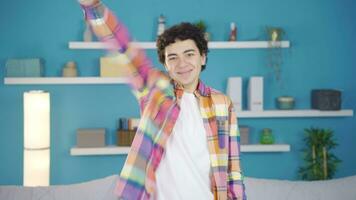 Cheerful adolescent male rejoices, looks at camera and smiles. video