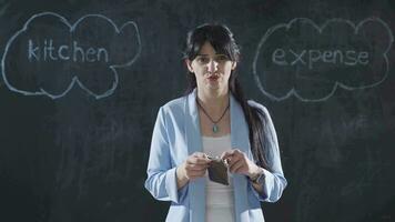 Woman writing Kitchen Cost on the blackboard is thoughtful and stressed. video