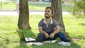 University dwarf student daydreaming outdoors in the park. video