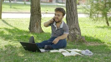 Young college dwarf student talking to his friend on the phone about lessons. video