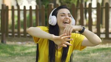 Woman sitting on the floor with joy listens to music. video