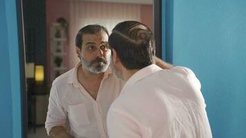 Man using tweezers looking in mirror. video