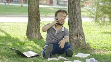 olycklig högskola dvärg- studerande talande på de telefon. video