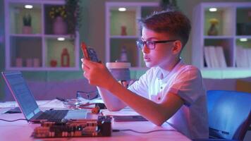 niño examinando un computadora tablero con electrónico circuitos con admiración. video