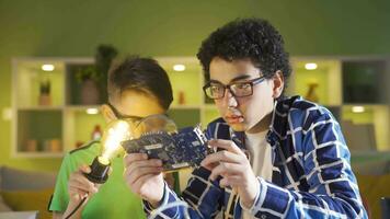 às lar, dois amigos estão examinando uma peça do tecnológica computador. video