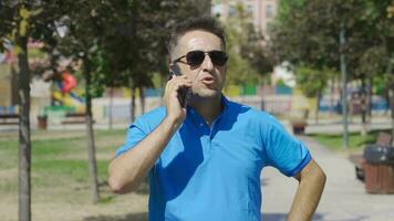 homem falando em a telefone ao ar livre. video