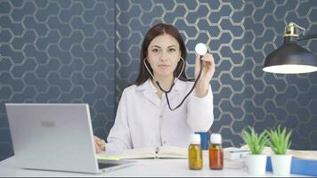 Woman doctor listening to camera with stethoscope. video