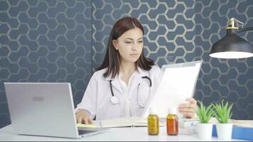 The woman doctor examining the paperwork is thoughtful. video