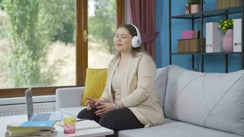 Woman looking out the window and listening to music with headphones. video