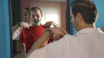 Man rehearsing clothes looking in mirror. video