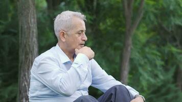 Man sitting in the park with an offended expression. video