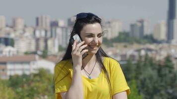 mulher falando em a telefone ao ar livre. video