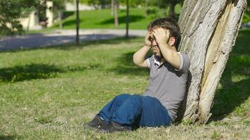 Dwarf young man sitting on the ground in panic. video