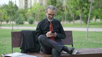 Phone addict Businessman using phone outdoors. video