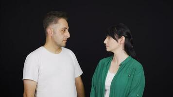 Man and woman looking at each other with dull expression. video