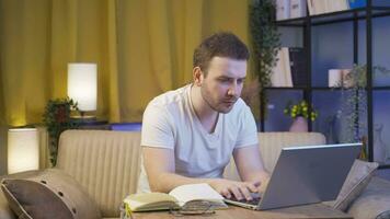 Man focusing on computer has serious expression. At home at night. video