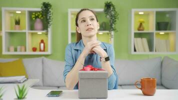 The young woman, who is looking at her watch with excitement, will give her gift. video