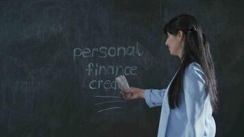 The woman who writes Consumer Loans on the blackboard looks with a happy expression. video