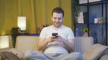 The man who texts on the phone at home at night is disappointed. video