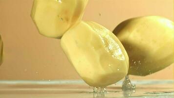 Peeled potatoes fall on a wet table. Filmed on a highspeed camera at 1000 fps. High quality FullHD footage video