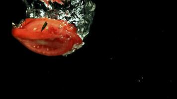 tranché tomates tomber en dessous de l'eau. filmé sur une grande vitesse caméra à 1000 ips. haute qualité Full HD métrage video