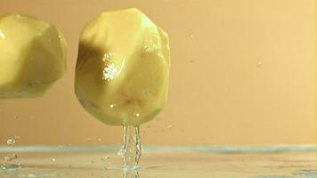 Peeled potatoes fall on a wet table. Filmed on a highspeed camera at 1000 fps. High quality FullHD footage video