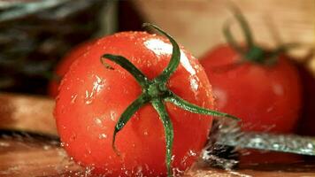 A tomato falls on a wet cutting board. Filmed on a highspeed camera at 1000 fps. High quality FullHD footage video