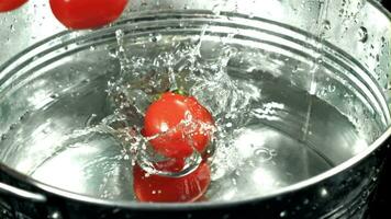 Tomates otoño dentro un Cubeta de agua. filmado en un alta velocidad cámara a 1000 fps. alto calidad full HD imágenes video