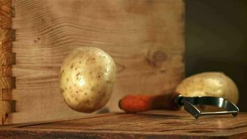 Potatoes fall on a wooden board. Filmed on a highspeed camera at 1000 fps. High quality FullHD footage video