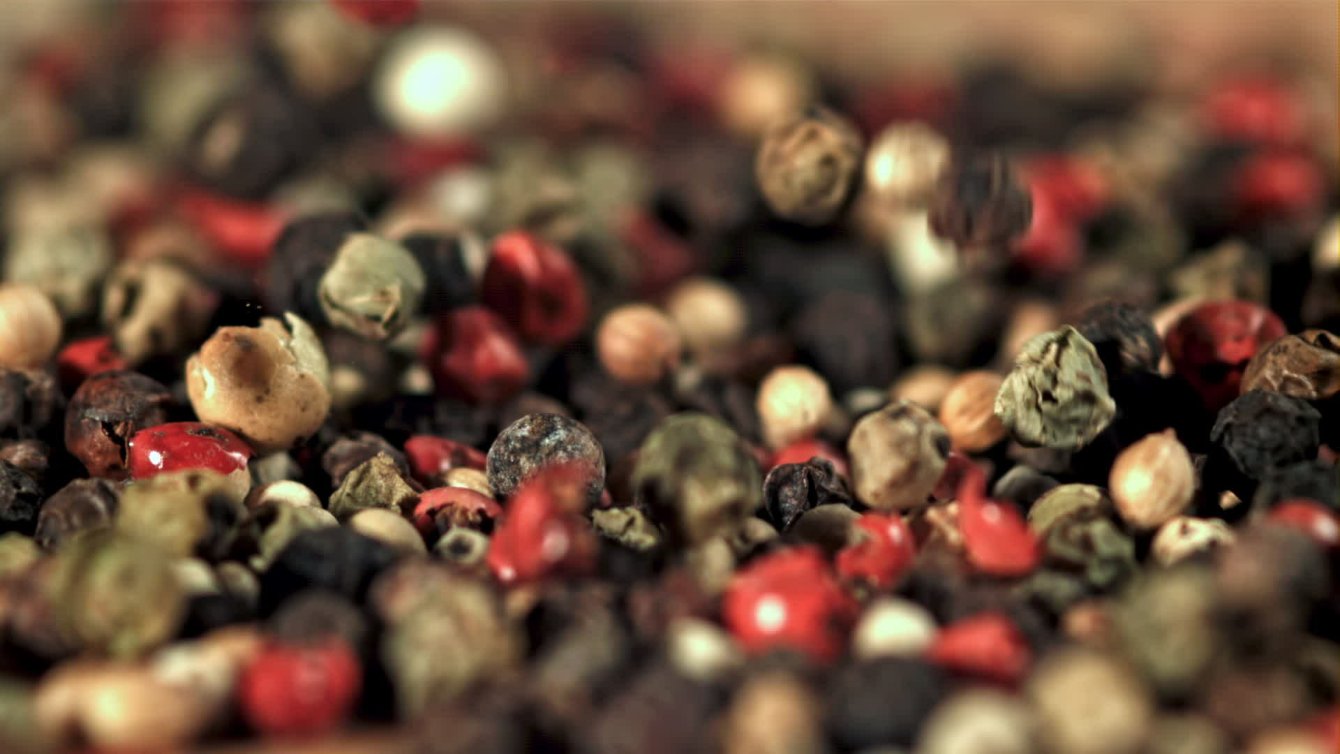 Peppercorn falls into a pile of grains. Filmed on a highspeed camera at