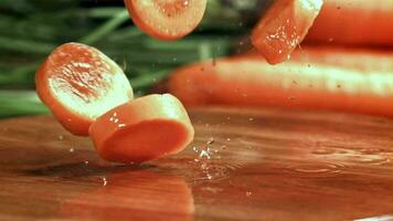 bitar av hackad morötter falla till en våt styrelse. filmad på en hög hastighet kamera på 1000 fps. hög kvalitet full HD antal fot video